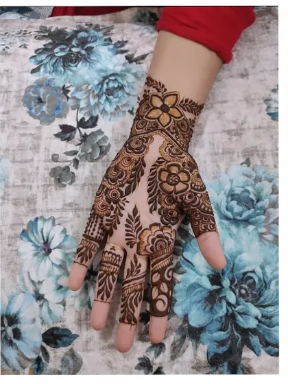 A beautiful floral design on the back of the hand, featuring a mix of bold flowers and delicate leafy vines.