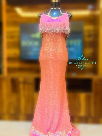 This full-length view shows the elegant mermaid silhouette of our pink and orange ombre sequin gown. The ruffled bodice adds a soft touch to the otherwise sleek and sparkling design.