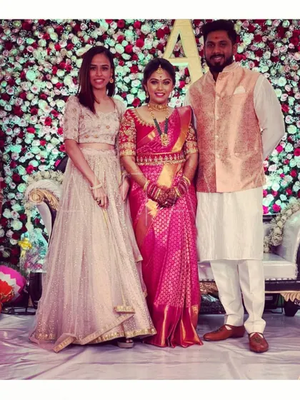A candid shot from a wedding, featuring a client in her custom hand-embroidered lehenga alongside family members also wearing my designs, including a custom Bundi jacket.