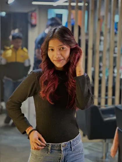 "Red hair, don't care" is the attitude. This image showcases a beautiful, vibrant red balayage on dark hair, styled with soft waves.