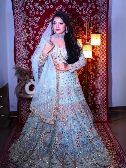 A full view of the sky-blue peacock lehenga against a rich red backdrop, showing its versatility and beauty.