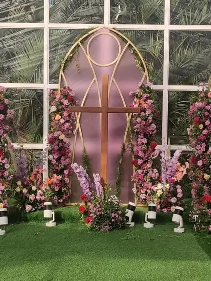 A closer view of the ceremony backdrop, designed with shapes and patterns found in classic church architecture. The floral arches add softness and color to the structure.