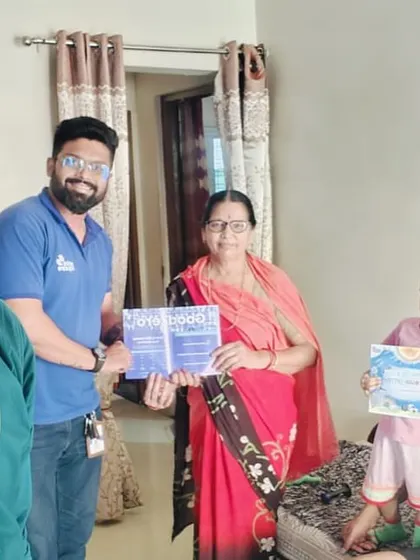 A family, including a young girl, receives their solar information packets. We are building a better future for the next generation.