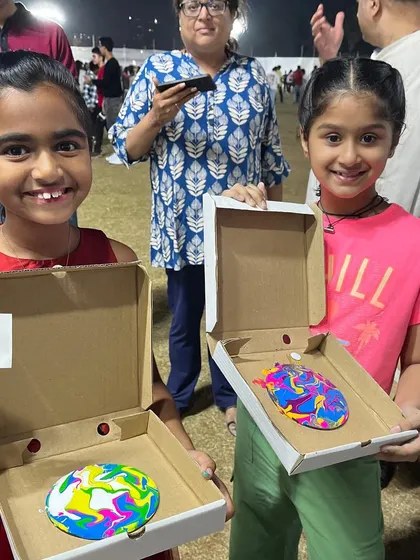 Two happy girls showing off the colorful fluid art coasters they created at my carnival booth. The unpredictable and beautiful results of paint pouring are always a delight.