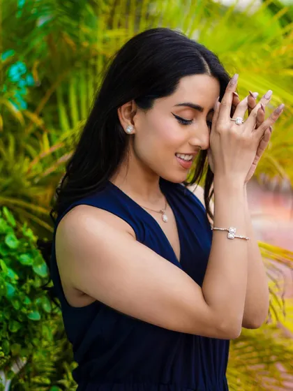 A soft, candid-style photo from the jewelry campaign. The model's smile and gentle pose create a warm and inviting image, showcasing the products in a relatable way.