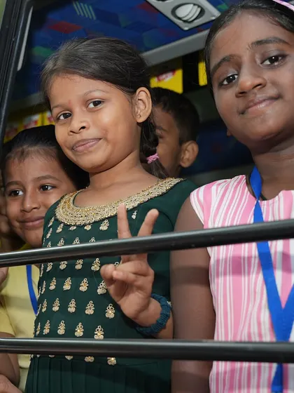 The bright, smiling faces of children looking out from our music bus, a space where they can learn and dream.