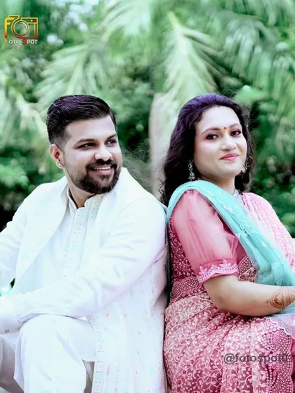 A classic engagement portrait with the couple sitting back-to-back. The groom's glance towards the bride adds a touch of romance and connection to the shot.