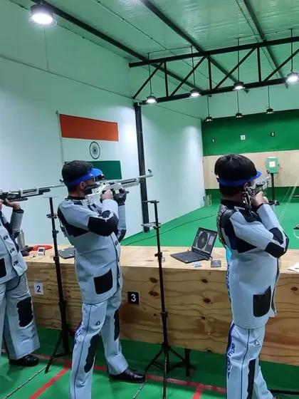 A team of rifle shooters practicing in unison, all wearing their official shooting jackets and trousers for optimal stability and form.