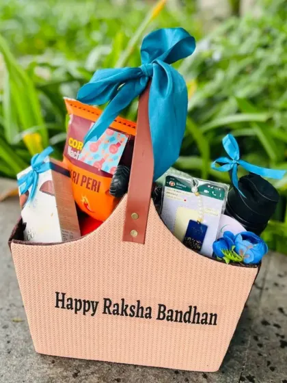 A stylish Raksha Bandhan hamper for a "Bhaiya & Bhabhi" in a modern tote bag. The bright blue satin ribbon adds a pop of color to this festive gift.