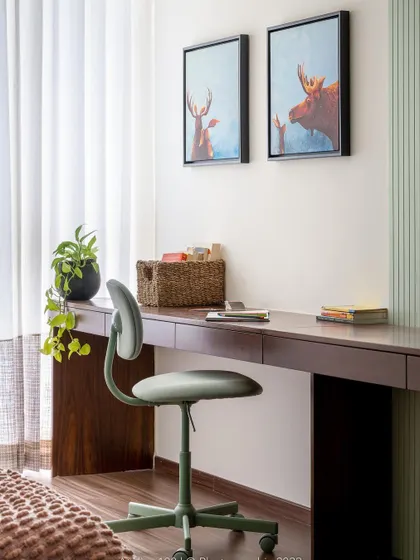 A study space that inspires creativity. The sage green color palette continues here with a simple desk and ergonomic chair, creating a calm and focused environment for learning or working from home.