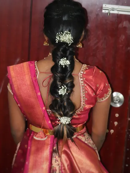 A beautiful messy braid hairstyle, perfect for a pre-wedding event or a reception. This style is adorned with delicate baby's breath flowers, adding a touch of romance.