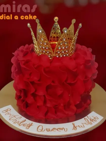 A cake for a birthday queen, this design features a vibrant red rosette frosting and is topped with a sparkling gold crown. It's a bold and beautiful statement piece.