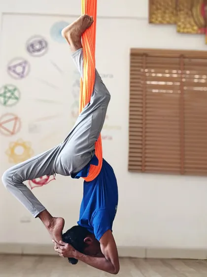 An advanced inversion in the aerial hammock, this pose requires significant core control and upper body strength.