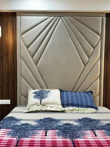 This bedroom features a stunning custom headboard with geometric upholstery and vertical wood paneling, complemented by a hanging pendant light for a modern, luxurious feel.