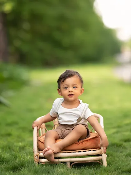 This little muffin sitting in a miniature cane chair on the green grass is the definition of adorable. Outdoor sitter sessions are perfect for capturing this stage.