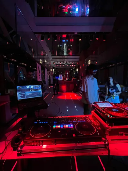 My setup at a club, bathed in red light. This is my workstation, where I blend sounds and create the vibe for the night.