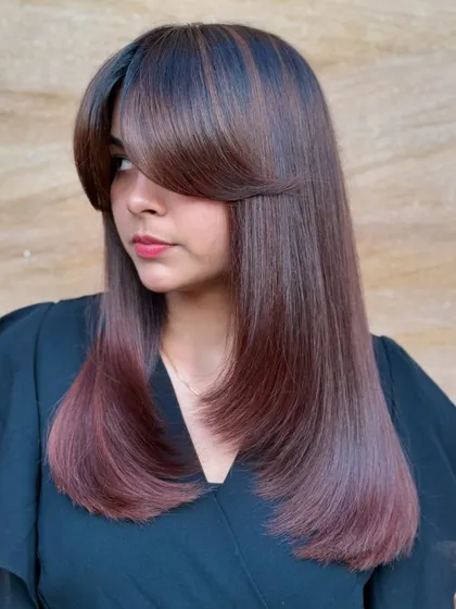 A modern, edgy look with sharp, straight lines and a bold fringe. This cut is paired with a subtle color melt for a high-fashion feel.