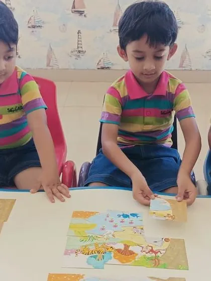 A group of preschoolers collaborates to piece together a floor puzzle. This activity fosters communication and shared goal achievement.