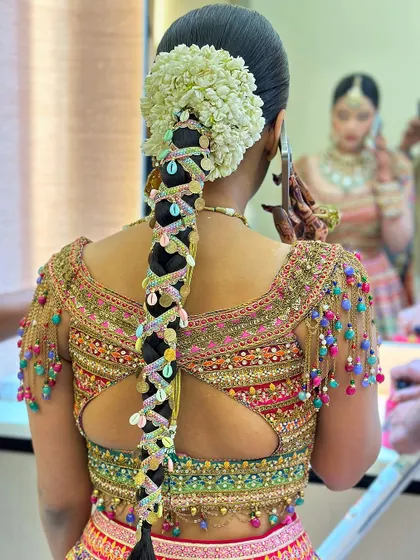 A festive and colorful braid for a Teej function. This look incorporates gota patti and vibrant shells, matching the joyous spirit of the occasion.