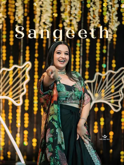 A portrait of the bride pointing playfully at the camera during her Sangeet night, her personality shining through.