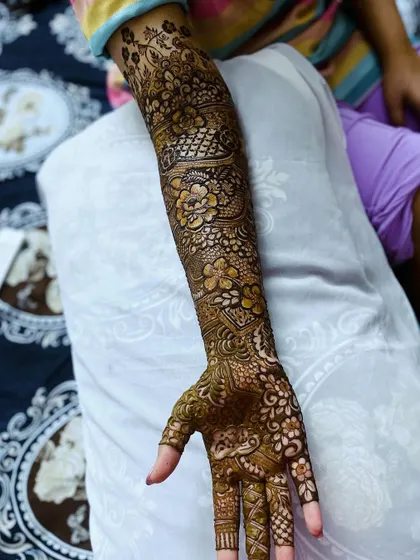 A single arm view of the bridal henna, showing the beautiful flow of the design from hand to elbow.