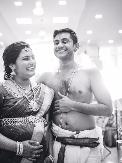 A candid black and white shot of a couple sharing a joyful moment during their Valaikappu or Seemantham ceremony.