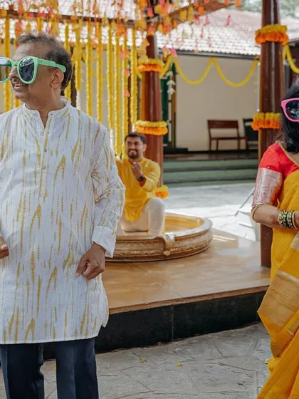 Even the elders get into the spirit of the Haldi carnival! Guests enjoying the celebration with fun, oversized sunglasses.
