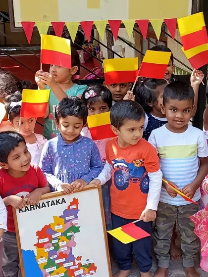 Children celebrating Kannada Rajyotsava, proudly holding the Karnataka flag.