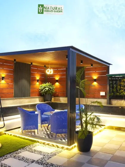 A cozy corner in the Palam Vihar project, with a pergola, comfortable blue chairs, and a swing.