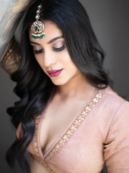 Embracing chic makeup with a touch of elegance. This close-up shows the soft pink eyeshadow and bold berry lip, a perfect combination for a modern bride.