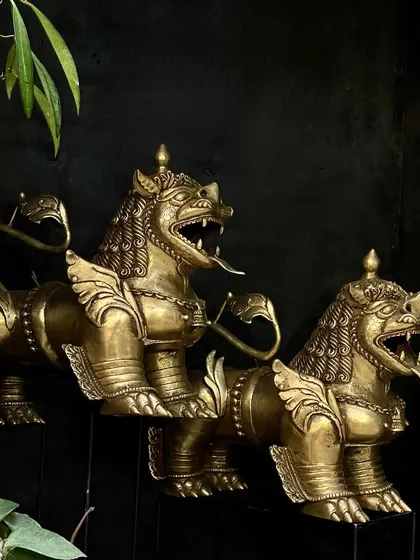 A pair of Buddhist temple lions, handcrafted from brass with their tongues out to ward off evil. These guardians are meant to be placed at an entrance, bringing protection and a sense of history to your home.
