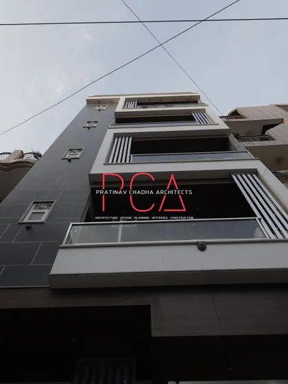 A low-angle daytime shot looking up the facade of The Cursive Abode, emphasizing its height and modern aesthetic.