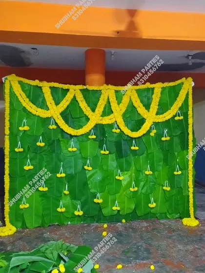 A traditional Simmanta decoration featuring a backdrop made of fresh banana leaves and marigold flower garlands.