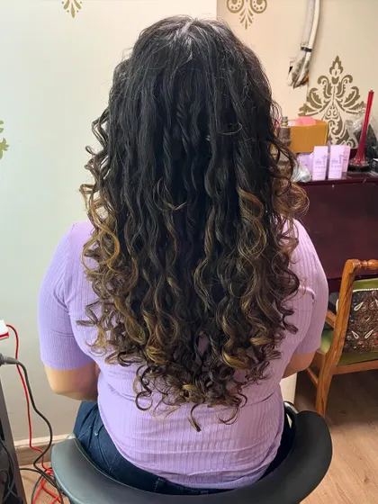 The back view of Dnyaneshwari's long curly hair, showing off the length and healthy curls.