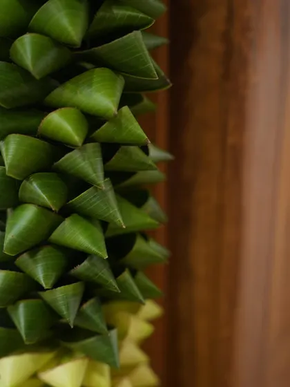 A close-up of a traditional floral element made from folded banana leaves. This kind of intricate, natural detail is perfect for adding an authentic touch to a Grah Pravesh or housewarming ceremony.