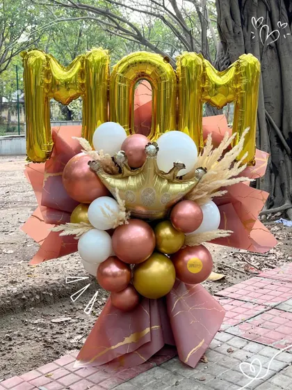 For the queen of the house! This "MOM" balloon bouquet is adorned with a crown and beautiful rose gold and white balloons.
