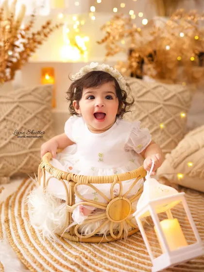 The brightest smile! This happy baby girl is holding a lantern, adding a touch of magic to her boho-themed birthday photos.
