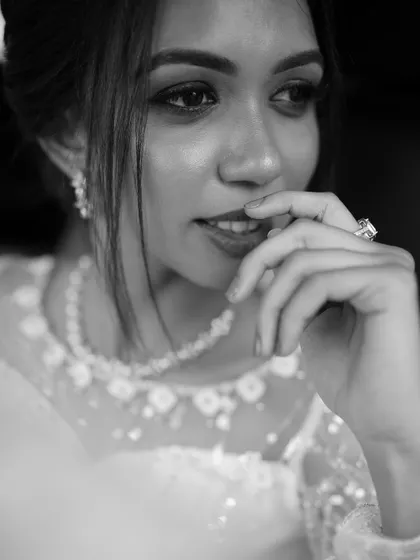 A thoughtful black and white portrait of a bride, highlighting her expression and the details of her ring and necklace.