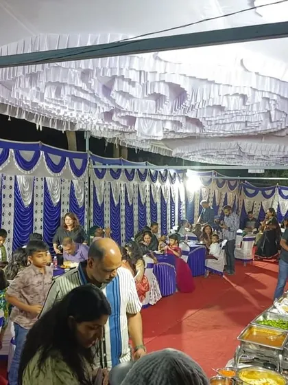 A wide shot of a bustling housewarming party. Our buffet line is strategically placed for easy access, ensuring guests can enjoy the food without long waits.