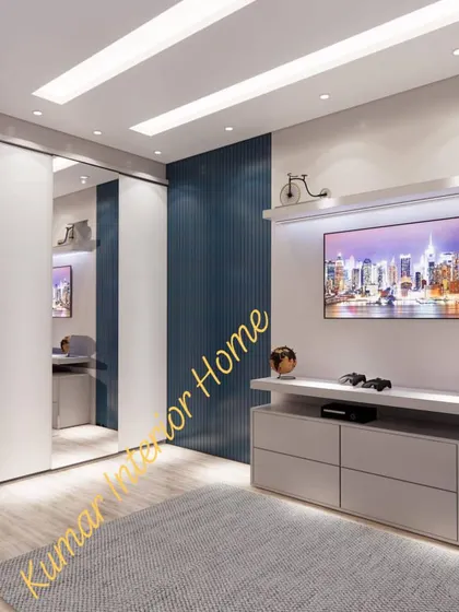 A bedroom with a mirrored sliding wardrobe and a built-in TV and desk unit.