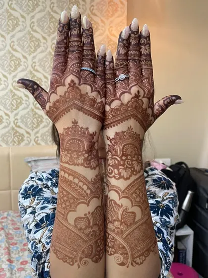 A full view of a gorgeous, dark henna stain, held up proudly by the client.