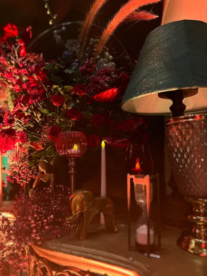 A close-up of vintage-style props, including an hourglass, golden elephant figures, and candle holders, all contributing to a rich, layered, and story-filled decor.