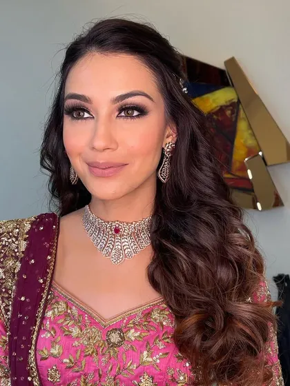 A glamorous sangeet look with bold, defined waves and a deep side part. This style is perfect for making a statement.