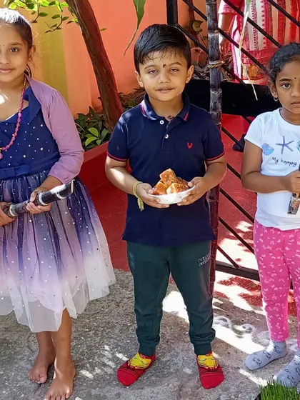 Children enjoying the festive treats during our Sankranti celebration.