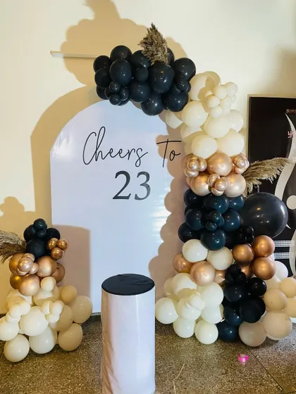 Another look at the modern "Cheers to 23" setup, showing the elegant script and the stylish balloon arrangement.