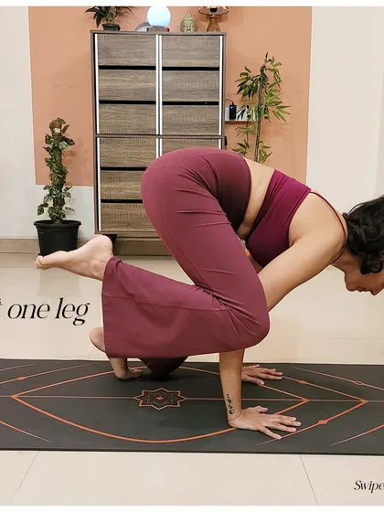 The next step in crow pose is lifting one leg at a time to get used to the weight transfer onto your hands.
