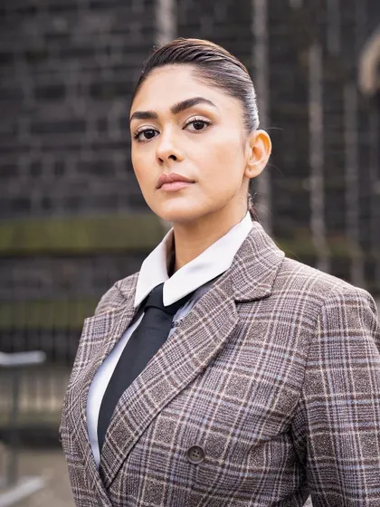 A serious, confident portrait. The tailoring of this custom suit is impeccable, creating a strong and commanding silhouette.
