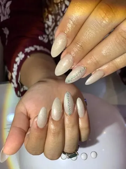 A beautiful example of elegant, shimmering nail extensions perfect for weddings or special occasions. We teach how to create this subtle glitter effect and apply delicate rhinestone accents.