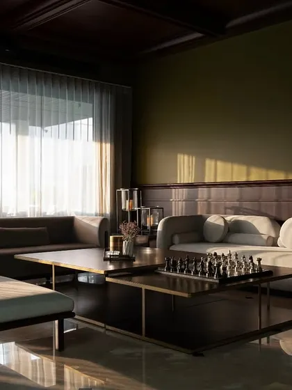 The reflection on the marble floor highlights the abundance of natural light in this room. The layout is designed to be open and spacious, allowing for easy movement and conversation.