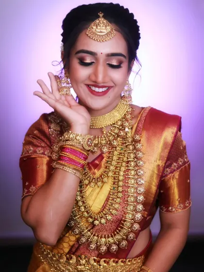 A close-up of a model wearing a stunning Kerala bridal set, highlighting the intricate details of the coin necklaces (Kasu haram).